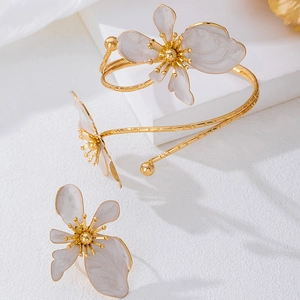 Golden flower jewelry set with white enamel petals including open bangle and ring for women