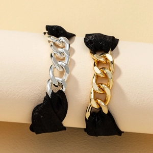 Ensemble de bracelets élastiques noirs avec chaînes dorées et argentées sur un support