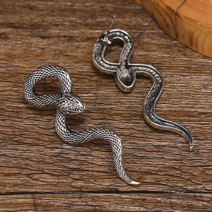 Punk antique silver snake earrings with detailed serpent scales on dark wood background