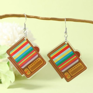 Retro TV earrings with rainbow stripes in acrylic, hanging on a wooden branch