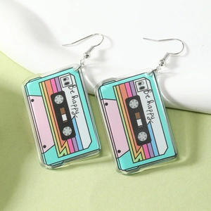 Macro detail of retro colorful acrylic cassette tape earrings with Be Happy print