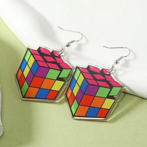 Dettaglio macro di orecchini a cubo di Rubik 3D in acrilico con motivi geometrici