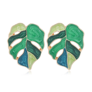 Boucles d'oreilles feuille de monstera dorées avec émail multicolore sur fond blanc uni