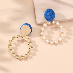 Detailed close-up of blue woven earrings with gold accents and white pearl inlay