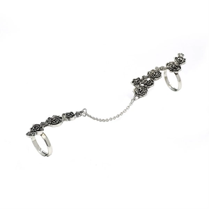 Detailweergave van een vintage zilveren dubbele ring met rozenclusters en metalen ketting