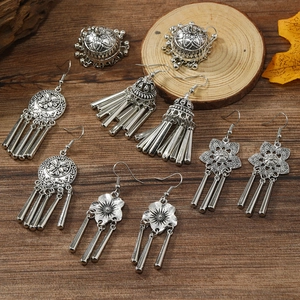 Ethnic bohemian silver drop earrings set with hollow floral patterns and bells on wood