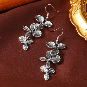 Macro-detail van retro bloemen oorbellen in antiek zilver met gelaagde bloemblaadjes