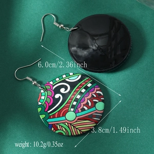 Detail view of large acrylic round earrings with ethnic floral patterns and hook clasp