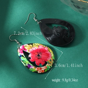 Detail view of water-drop acrylic earrings featuring floral prints and solid black finish