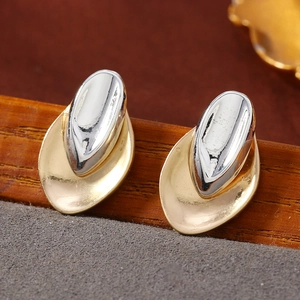 Vista macro de pendientes geométricos asimétricos bicolor en tonos dorado y plateado