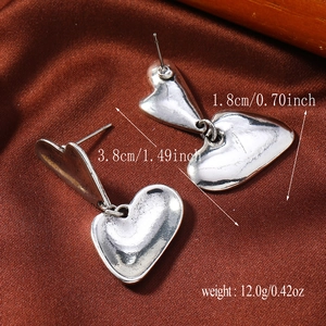 Detalle de pendientes de corazón plateados con medidas de 3,8 cm de largo y 1,8 cm