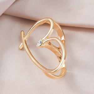 Nahaufnahme eines goldenen Herzrings mit kleinem Diamanten auf rosa Satinstoff