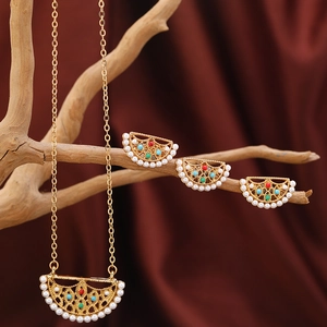 Detail von böhmischem Gold-Filigran-Schmuckset mit Perlen und bunten Perlen auf Holz