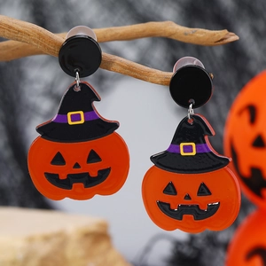Detailaufnahme origineller Halloween-Kürbis-Ohrringe mit schwarzem Hexenhut.