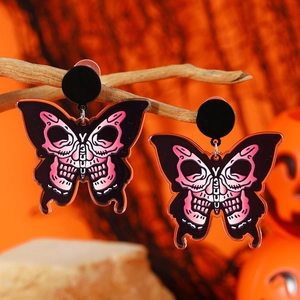 Gothic butterfly skull earrings in pink acrylic on wood branches with pumpkins