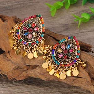 Detalle de pendientes bohemios con diamantes de imitación de colores y flecos dorados