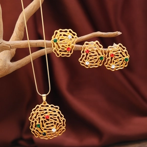 Detailansicht des goldenen Blumen-Schmucksets mit bunten Edelsteinen auf einem Ast