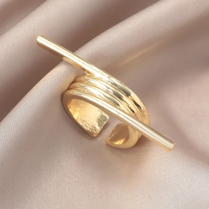 Makroaufnahme goldener unregelmäßiger Schleifenring mit mehrlagigem Design auf Seide