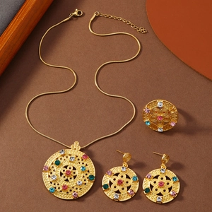 Detailansicht des goldenen Schmucksets mit hohlem Muster und bunten Strasssteinen am Tisch