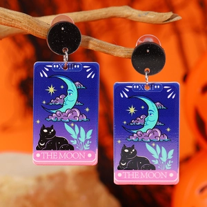 Gothic acrylic tarot moon earrings with black cat design hanging on wooden branch