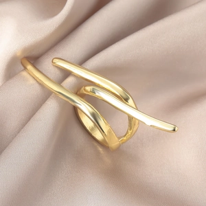 Makro-Detail des goldenen Schleifenrings auf elegantem champagnerfarbenem Satinhintergrund