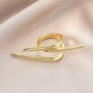 Makrodetail eines minimalistischen Goldrings mit geometrischer Form auf Seidenhintergrund
