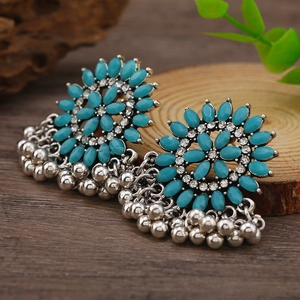 Detalle de pendientes Jhumka vintage con cuentas turquesas y borlas de cuentas metálicas