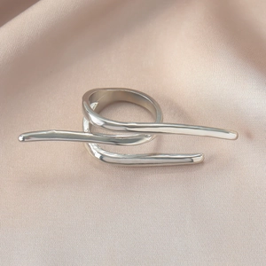 Detailansicht eines silbernen minimalistischen Rings auf rosafarbenem Seidenhintergrund