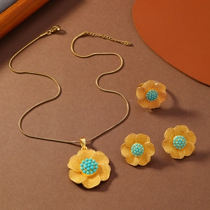 Flachbild von Vintage-Gold-Blumenschmuckset mit türkisfarbenen Perlen auf braunem Grund