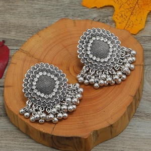 Detalle de pendientes étnicos plateados vintage con girasoles y cristales brillantes