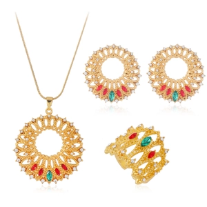 Makroaufnahme von vergoldetem Blumenschmuck-Set mit roten, grünen und weißen Steinen