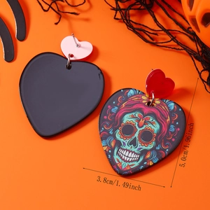 Dettaglio orecchini a cuore Halloween in acrilico con teschio su sfondo arancione