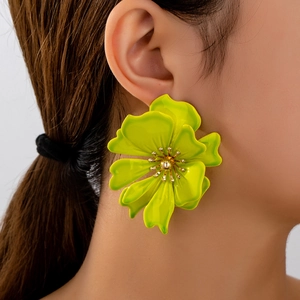 Vibrant lime green floral stud earrings with golden pistils in a stylish side-view shot