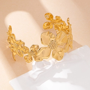 Elegante brazalete dorado de flores con cinco motivos florales sobre base con textura