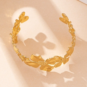 Sombra artística de un brazalete dorado para el brazo con detalles de flores finas