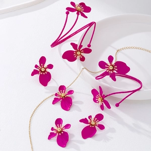 Dettaglio della collana con fiori rosso rosa e catena metallica dorata molto sottile