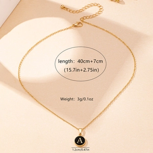 Minimalist gold necklace with black enamel letter A pendant on a thin link chain