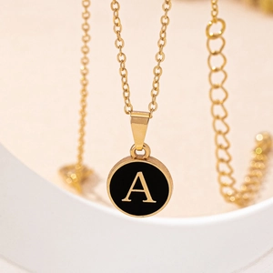 Elegant gold initial A pendant necklace with round black medallion on a chic cable chain