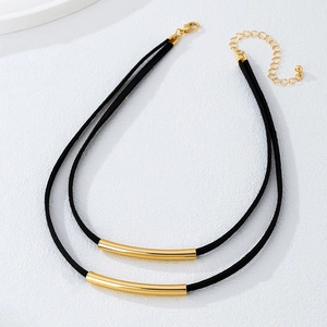 Dettaglio choker a doppio strato nero con pendenti a tubo dorato e chiusura regolabile