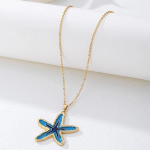 Detailopname van een blauwe zeester hanger met gouden rand aan een fijne ketting