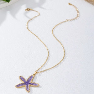 Detail van paarse zeester hanger met goudkleurige schakelketting en verstelbare karabijnsluiting