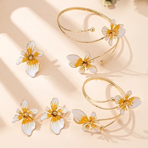 Vista dettagliata dei bracciali a fiori e orecchini con smalto sfumato arancione