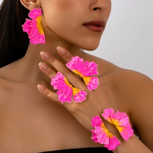 Detailed view of vibrant pink and yellow enamel flower earring and ring set on model