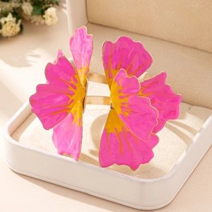 Detailed macro view of a floral bangle with pink and yellow enamel petals in a jewelry box