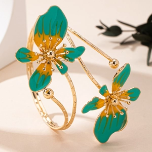 Dettaglio del bracciale aperto dorato con fiori in smalto sfumato verde e giallo