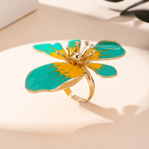 Dettaglio dell'anello a fiore con finitura dorata e smalto turchese e giallo