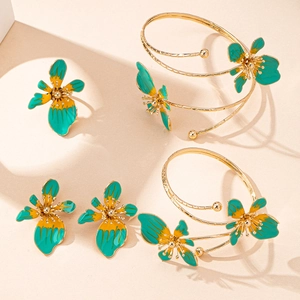 Dettaglio set gioielli floreali dorati con smalto verde e cristalli incastonati