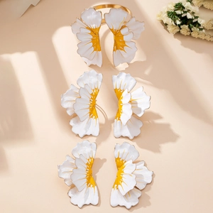 Detailed view of floral enamel bracelet and earrings set with petal design on beige backdrop