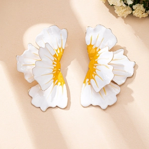 Detail of oversized enamel flower earrings with white and yellow petals and gold edges