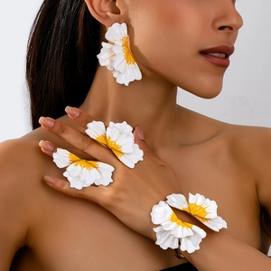 Detailed close-up of white flower jewelry set including earrings, ring, and open bangle